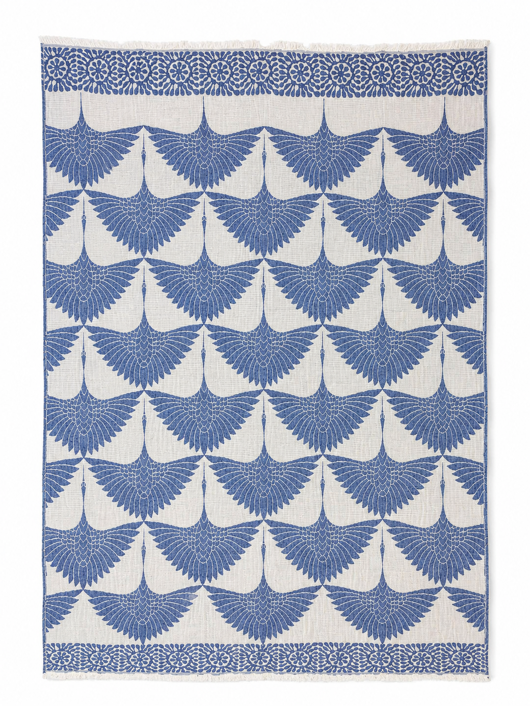 Crafted from soft Turkish muslin cotton, the Crane Muslin Throw Blanket Natural Border from turkanhome.com features a repeating blue crane design on a white background, with rows of spread-wing cranes and a decorative floral border at the top. This reversible Turkish cotton throw combines style and comfort, making it an ideal accent for your home.