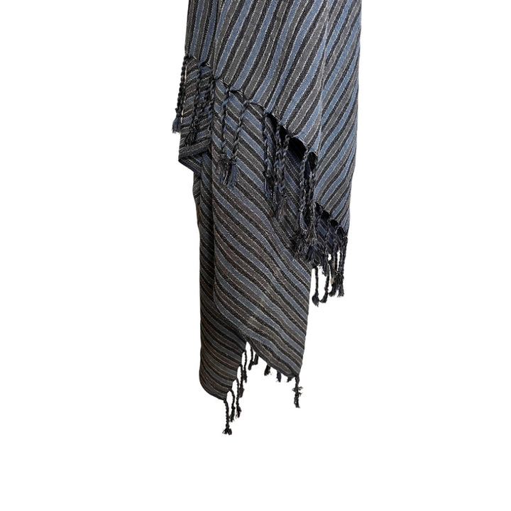 A close-up of the Black Sea Handwoven Turkish Towel, Throw, Shawl by turkanhome.com shows artisan stripes in black, gray, and blue with fringed edges, crafted from all-natural fibers against a white background.