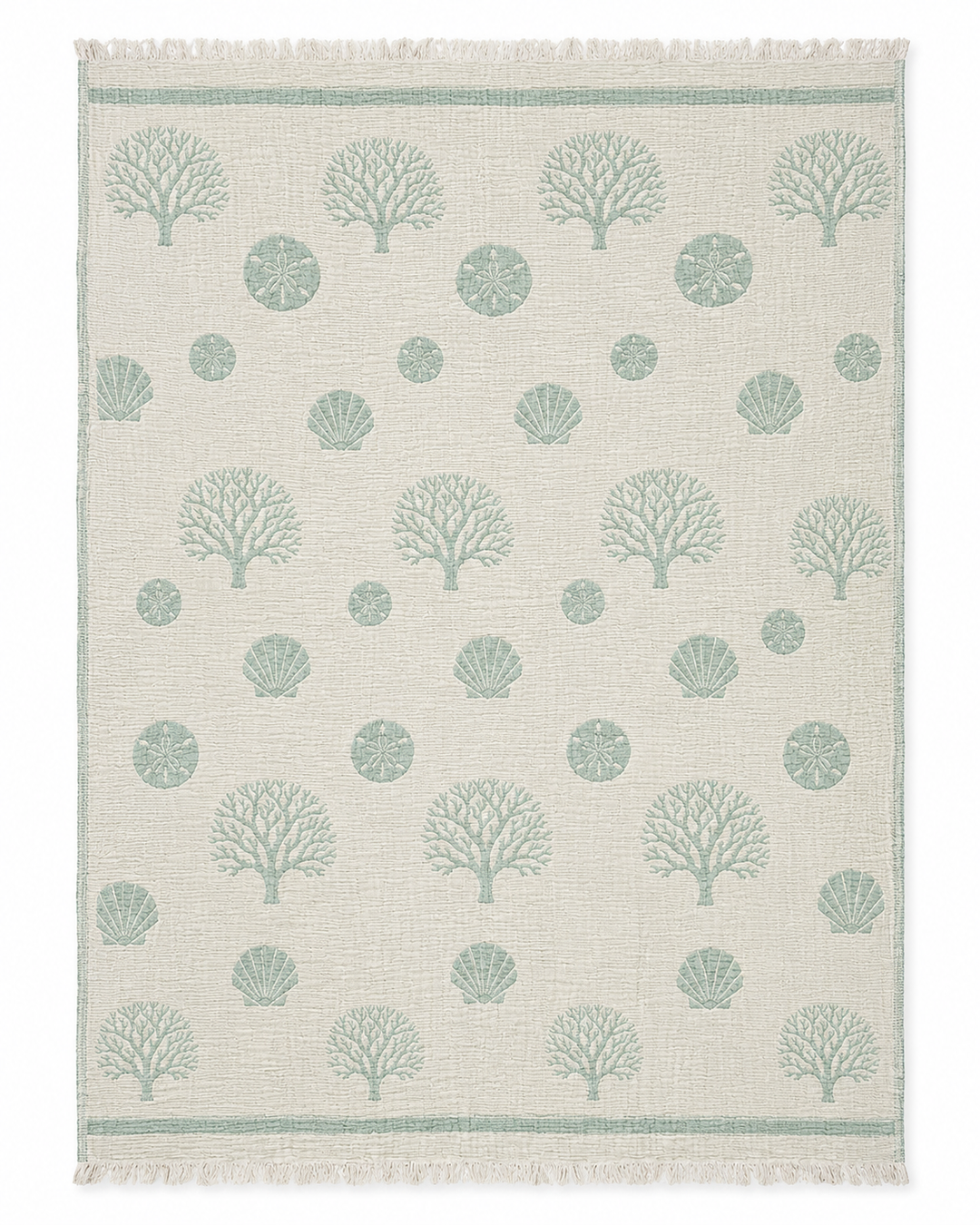 Experience coastal comfort with the Coastal Muslin Throw Blanket – Reversible Turkish Cotton by turkanhome.com, featuring a beige backdrop with green coral, seashell, and sand dollar patterns arranged in rows; fringed edges on the short sides add a classic Turkish touch reminiscent of seaside style.