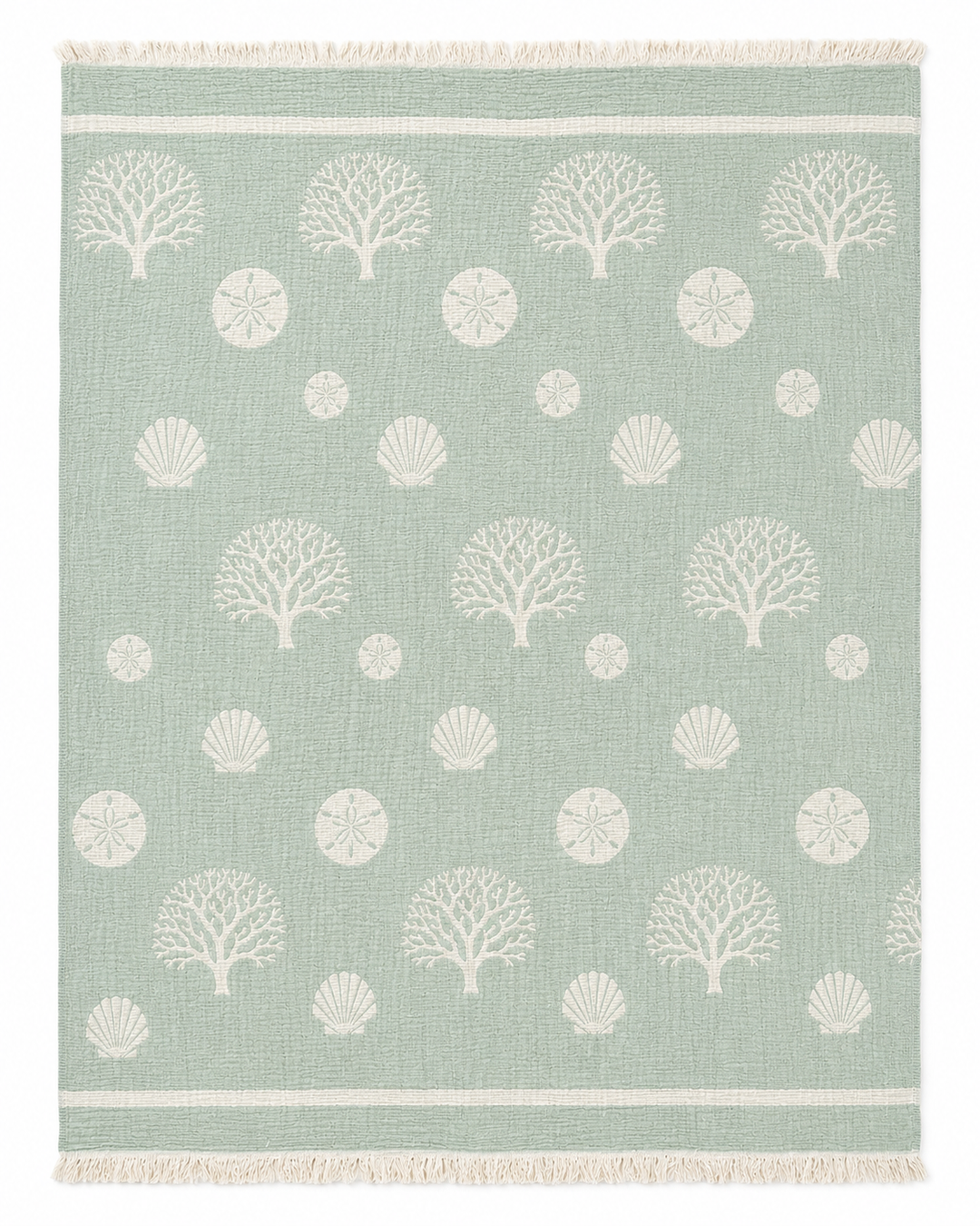 Infuse your space with a fresh coastal vibe by pairing this light green rug, adorned with white coral, sand dollar, and seashell patterns and finished with simple white stripes and fringed edges, alongside the Coastal Muslin Throw Blanket – Reversible Turkish Cotton from turkanhome.com.