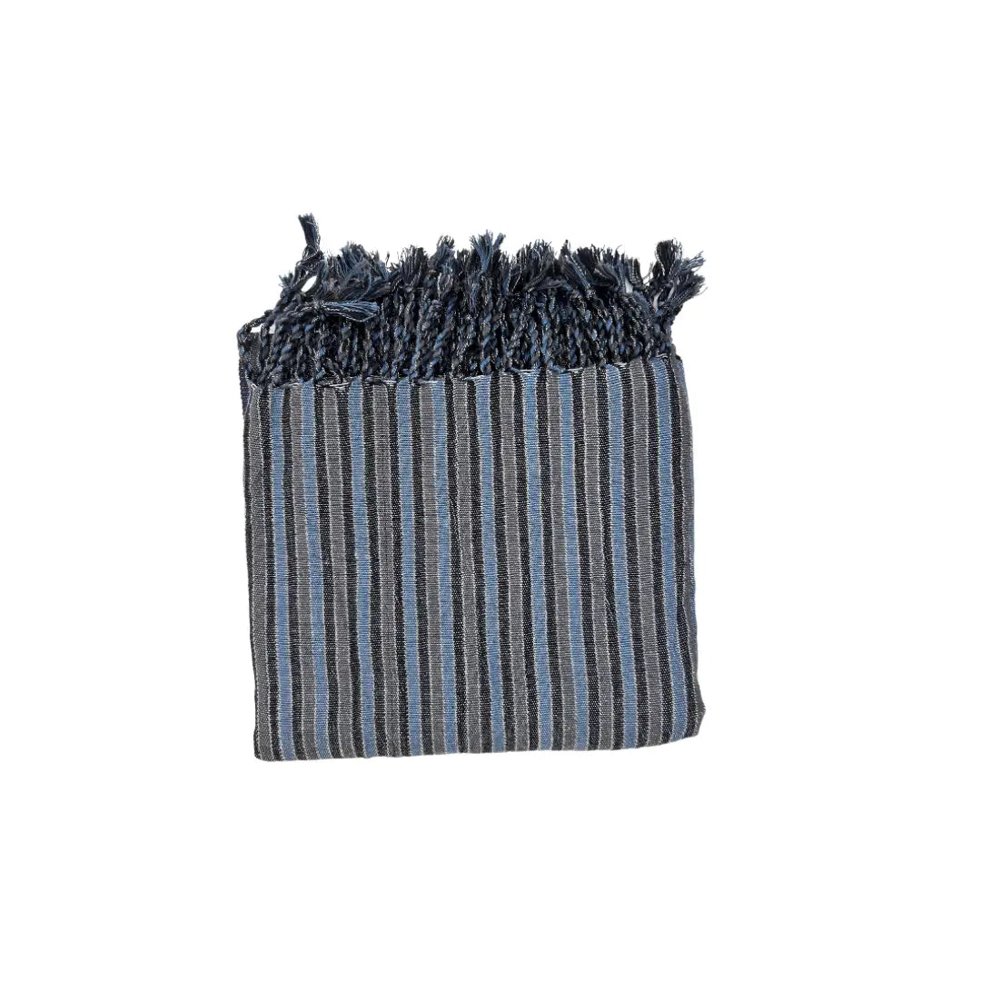 The Black Sea Handwoven Turkish Towel, Throw, Shawl by turkanhome.com—an artisan-crafted, rectangular piece with blue and gray stripes and fringed edges—made from all-natural fibers, is displayed folded against a white background.