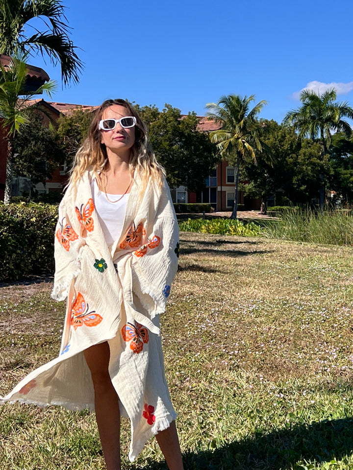 A woman wearing sunglasses and the Butterfly Kimono Robe-Natural Color from turkanhome.com.