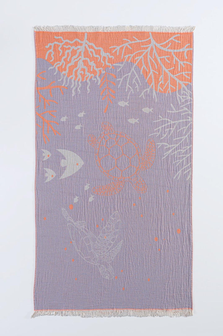 The Reef and Turtle Towel from turkanhome.com is a 100% cotton woven textile with fringed edges, featuring an underwater scene in orange, white, and lavender on a pale lavender background—perfect as a quick-drying Turkish towel.