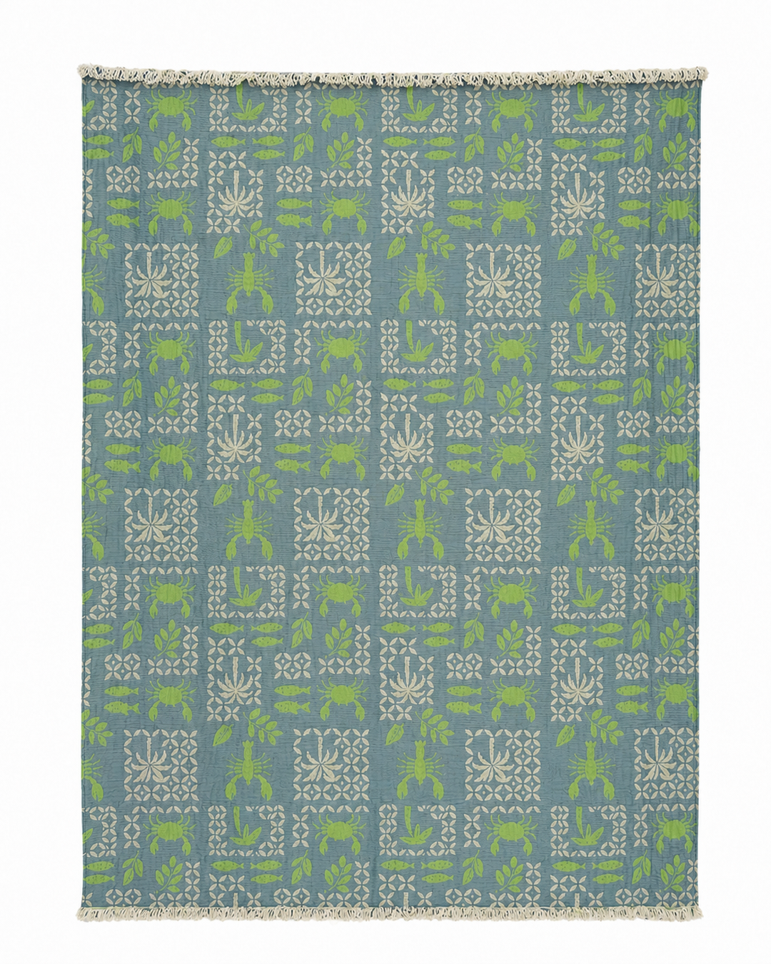 The Sea Life Muslin Throw Blanket – Reversible Turkish Cotton from turkanhome.com is a rectangular blue textile adorned with a symmetrical, all-over geometric pattern featuring white and green plants, animals, and shapes. Crafted from soft Turkish cotton, this elegant throw is finished with short white fringe along the edges, making it a stylish addition to any coastal-inspired décor.