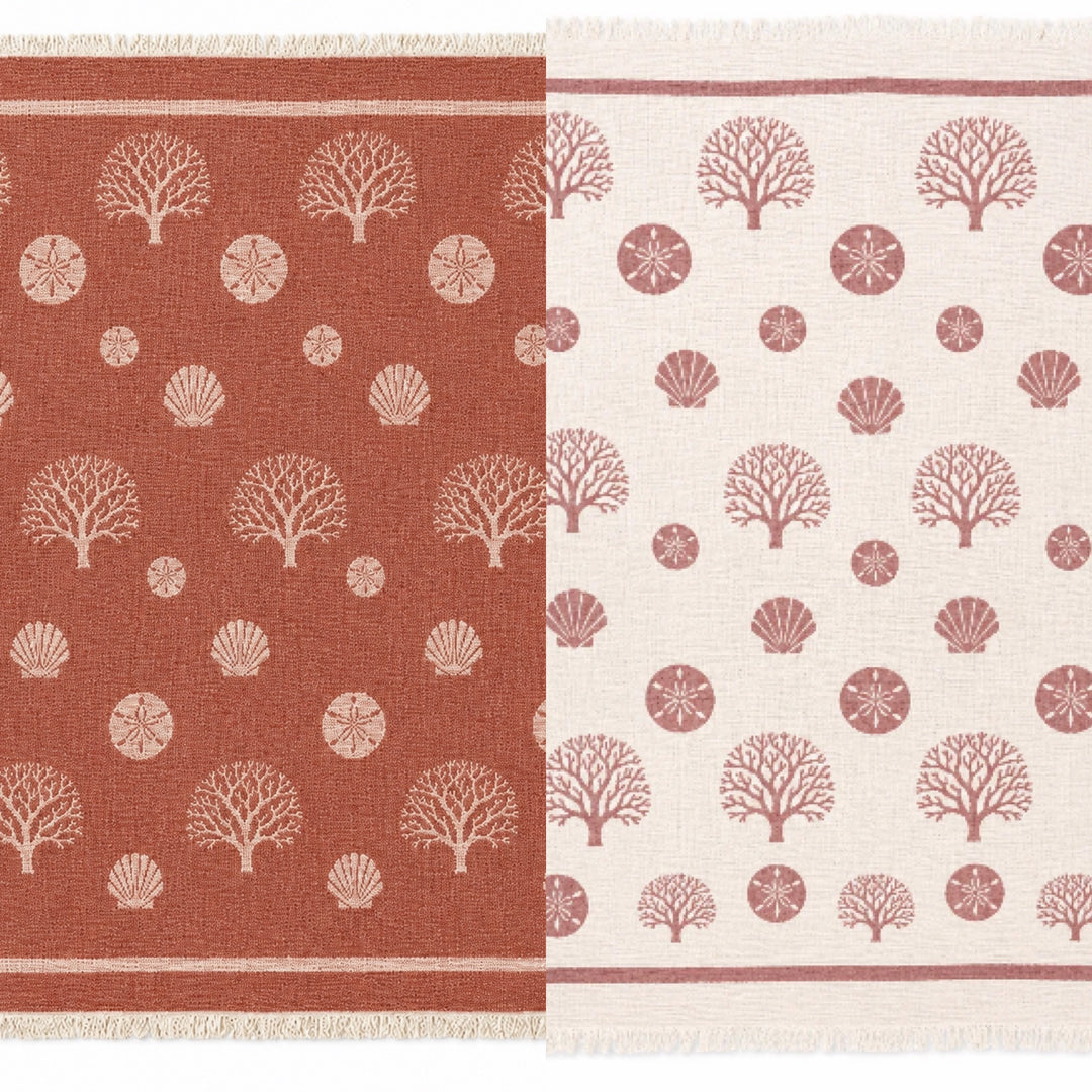 Two woven textiles from turkanhome.com are shown side by side: on the left, the Coastal Muslin Throw Blanket – Reversible Turkish Cotton appears in a rust hue, adorned with tan shells, sand dollars, and coral motifs; on the right, the same blanket is displayed in beige with rust-colored sea life patterns. Both sides feature soft Turkish muslin cotton and fringed edges, making this cozy, reversible coastal throw perfect for seaside retreats.