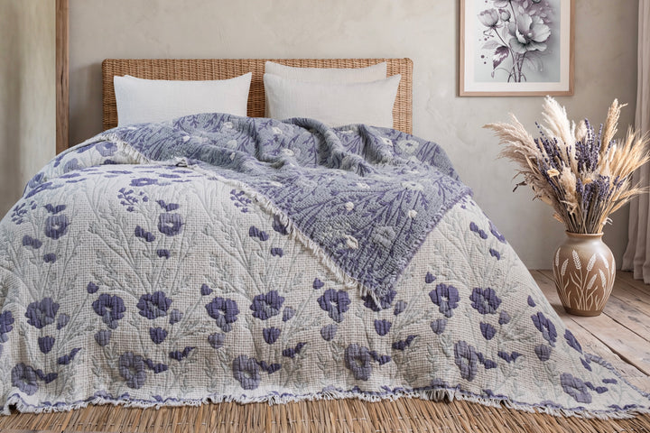 Purple floral quilt spread across a bed, showing both sides