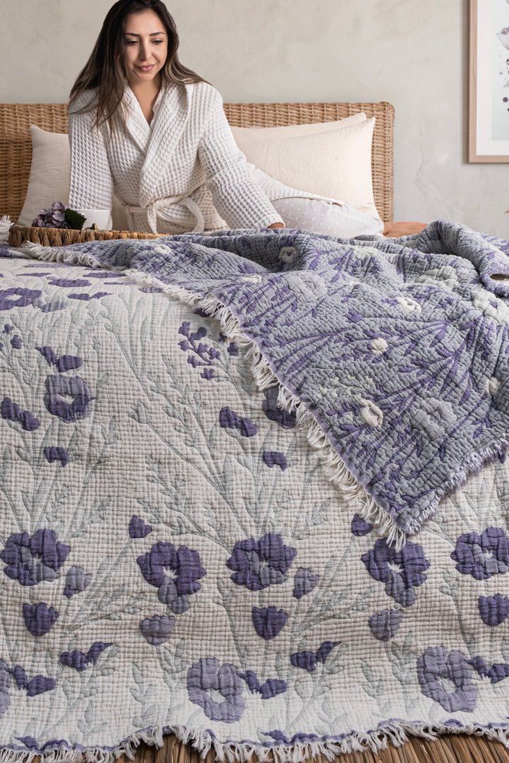 Purple floral quilt displayed on a bed